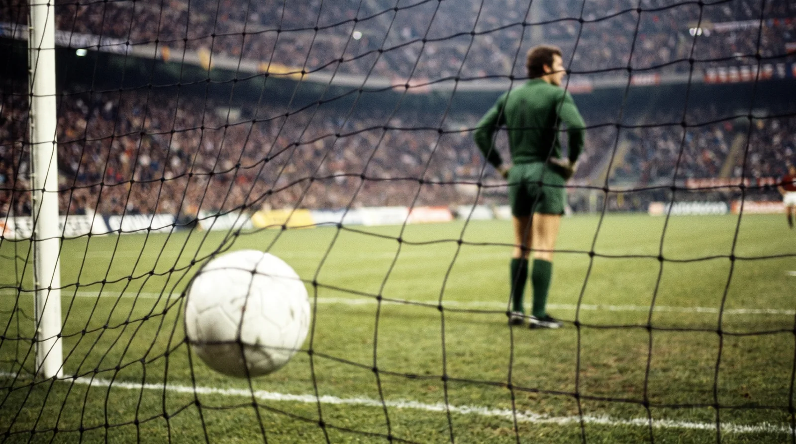 Pallone in fondo alla rete durante una partita serale: il gol che decide un Over o un Under
